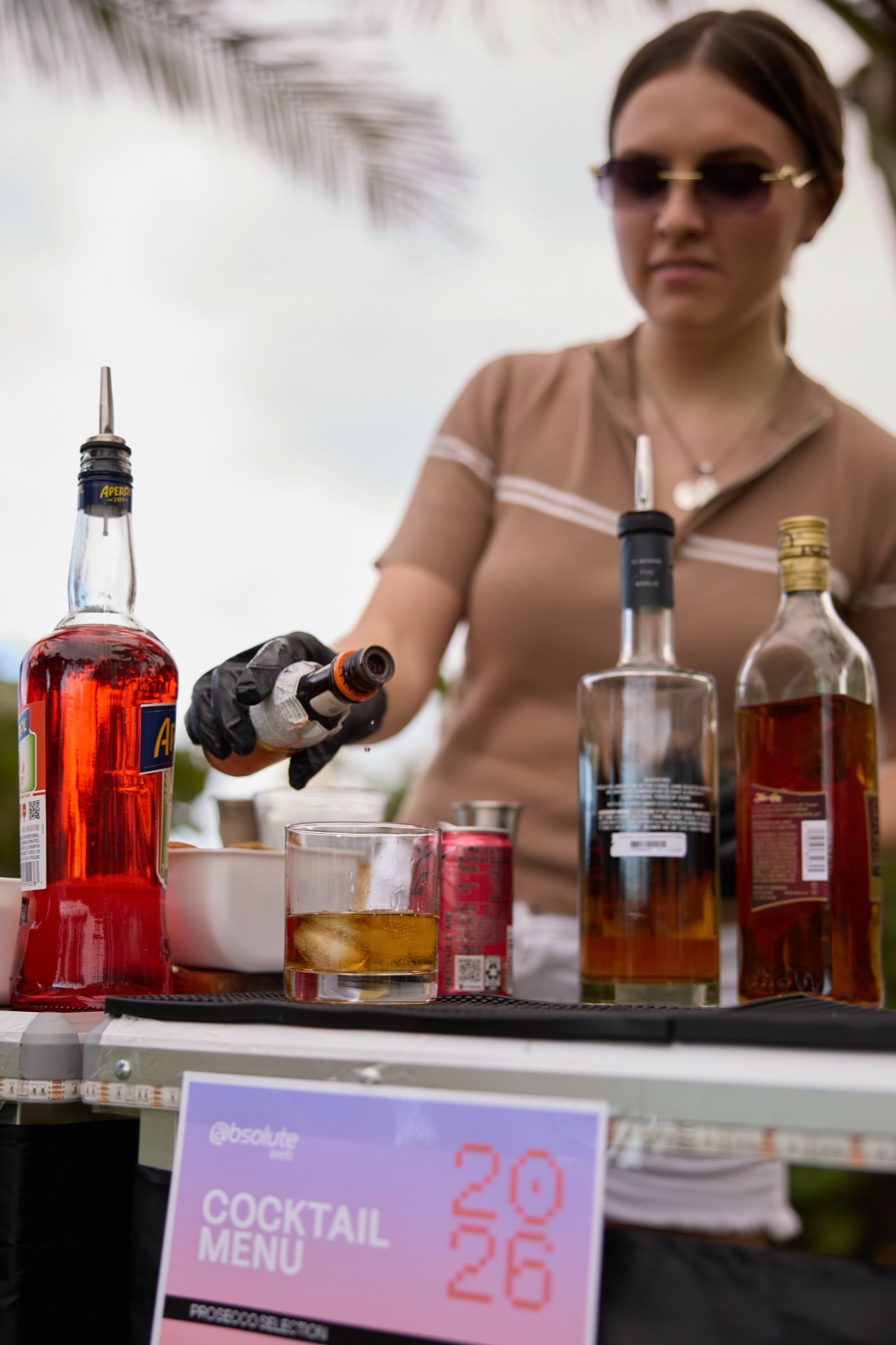 Bartender pouring cocktail with 2026 menu sign Miami