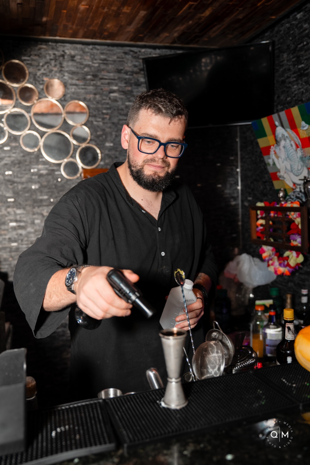 Bartender mixing cocktails at dark bar Miami