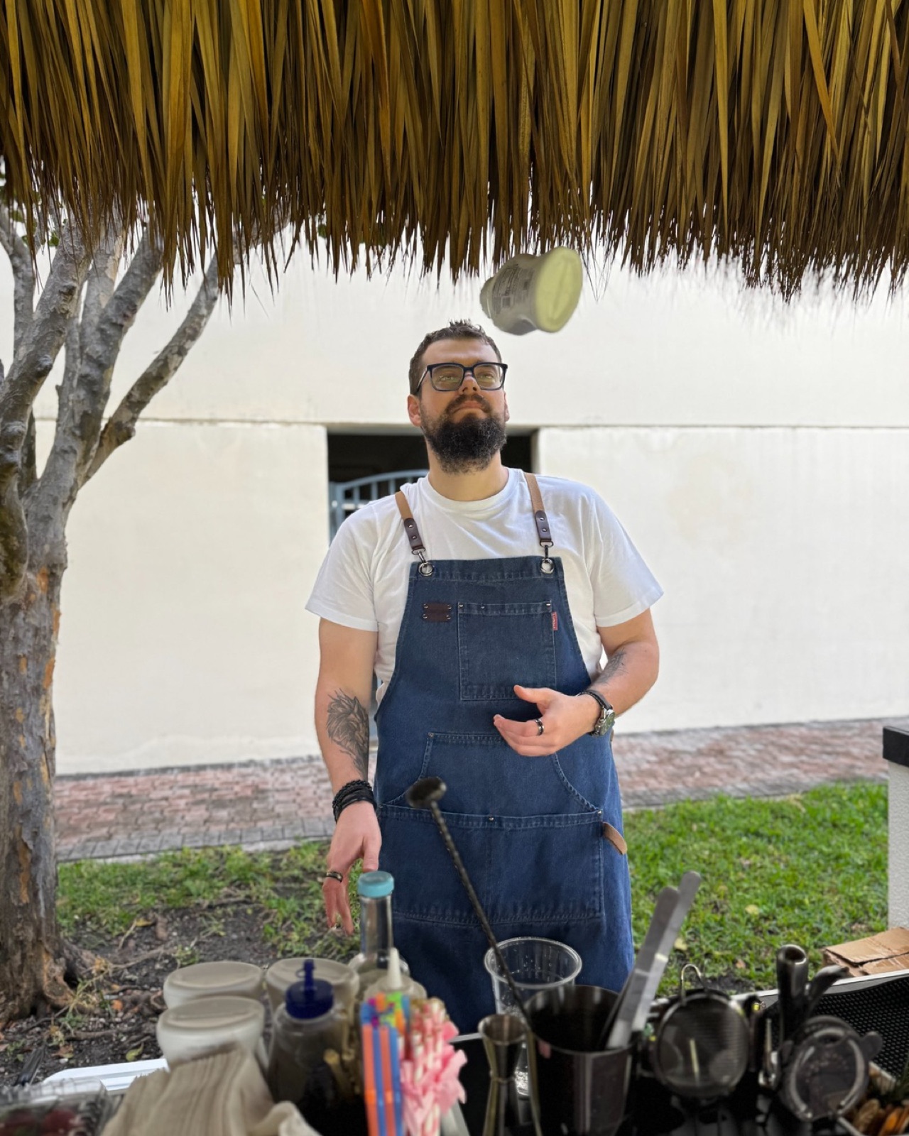 Bartender under tiki roof tossing lime Miami