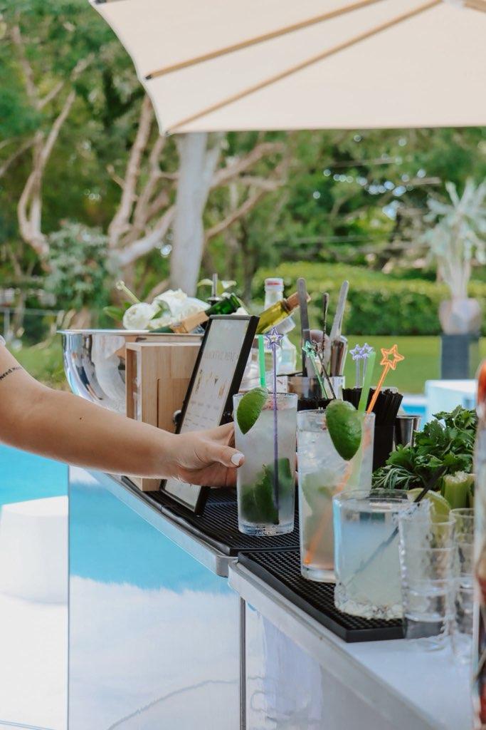 Poolside mobile bar with mojitos and umbrella at a Miami garden event