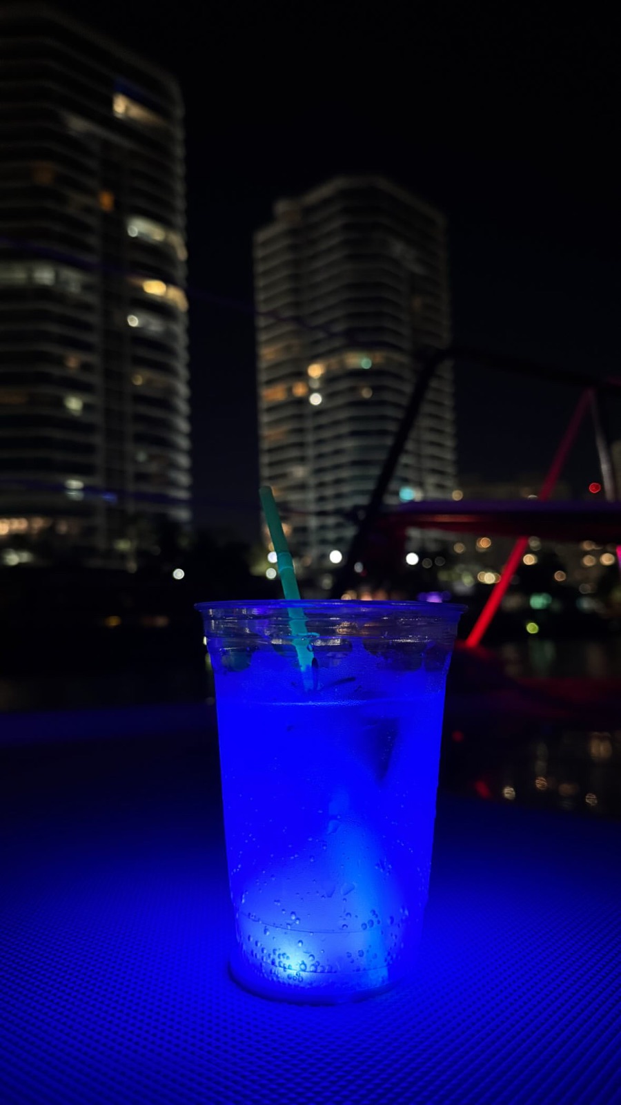 Blue glowing cocktail Miami skyline at night yacht party